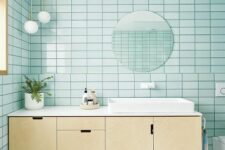 36 a gorgeous mid-century modern bathroom clad with mint blue tiles, a plywood floating vanity, white appliances