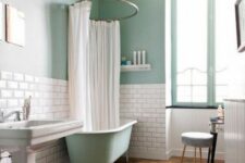 37 a mint blue bathroom with white subway tiles, a mint blue clawfoot tub, a free-standing sink and a chic pendant lamp