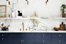 39 a sophisticated navy kitchen with shaker cabinets, a white marble backsplash, countertops and a ledge for displaying various stuff