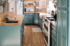 40 a stylish farmhouse kitchen in teal, with butcherblock countertops, a white backsplash and gold fixtures