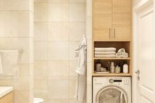 40 a warm-colored beige bathroom with large square tiles, a built-in washing machine and a cabinet, a vanity