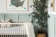 40 an airy and beautiful Scandinavian nursery with sage green paneling, a stained crub, neutral textiles, a potted plant and some art