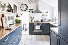 41 a stylish navy farmhouse kitchen with butcherblock countertops, a white ledge and a white beaded chandelier