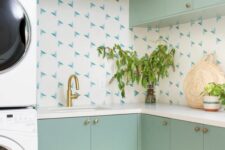46 a mint green laundry room with a catchy backsplash, gold fixtures and stacked appliances is a cool space