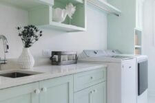 47 a mint green laundry room with elegant shaker cabinets, open shelves, a washing machine and a dryer, white stone countertops