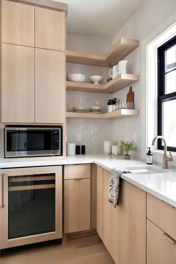 A chic light stained kitchen with sleek flat panel cabinets, white stone countertops and a white glossy tile backsplash