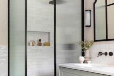 a modern farmhouse bathroom clad with white tiles, a greige vanity, fluted glass space dividers and black fixtures