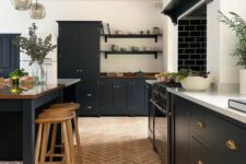 a modern farmhouse kitchen with a terracotta tile floor, black cabinets, a large kitchen island, pendant lamps