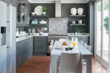 a modern grey kitchen with a glazed wall, a terracotta tile floor, graphite grey cabinets and a white dining set