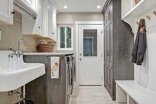 a neutral farmhouse mudroom laundry space with white and grey cabinetry, with shaker panels and an open storage unit