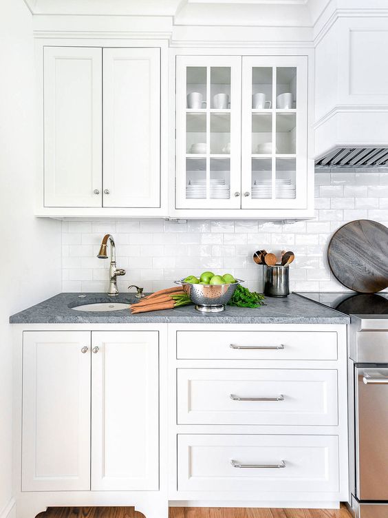 a pure white kitchen with shaker and glass cabinets, a white subway tile backsplash and grey granite countertops is lovely