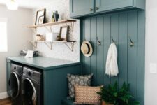 a small yet bright blue mudroom laundry with cabinets, an open storage unit, a washing machine and a dryer and open shelves