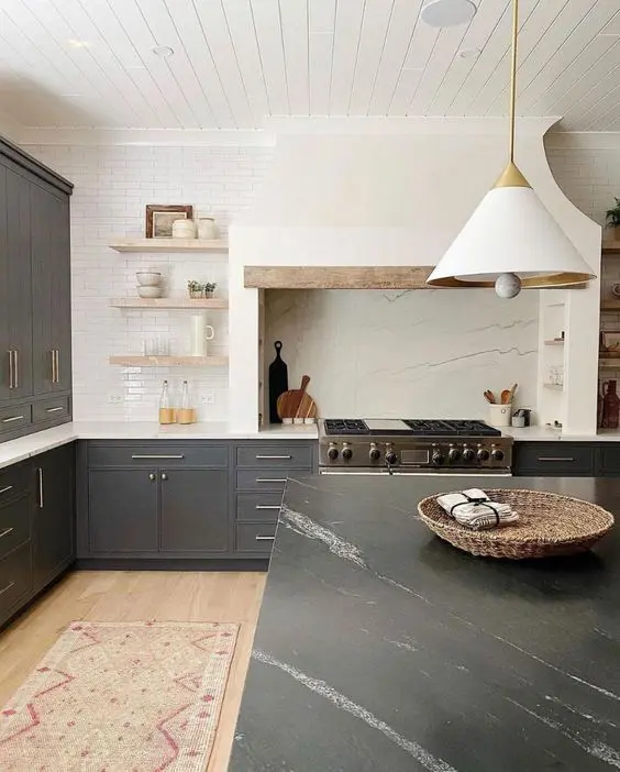 a stylish graphite grey kitchen with shaker cabinets, white countertops, open shelves, a built-in hood and a black soapstone countertop on the kitchen island
