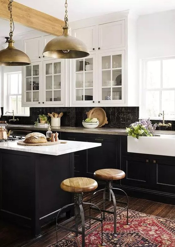 A vintage inspired kitchen with black shaker cabinets, white countertops and a black Zellige tile backsplash, metal pendant lamps
