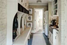 a welcoming mudroom laundry with an open storage unit with a bench, a washing machine and a dryer, shaker style cabinets