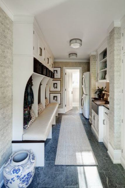 a welcoming mudroom laundry with an open storage unit with a bench, a washing machine and a dryer, shaker style cabinets