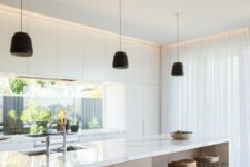 a white minimalist kitchen with a window backsplash, a stained kitchen island and black pendant lamps plus wooden stools
