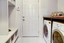 an all-white mudroom laundry with an open storage unit, a washing machine and a dryer and nothing else