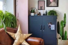05 a bright eclectic space with a pink and navy locker, a leather chair, a bright printed rug, a gallery wall and potted greenery