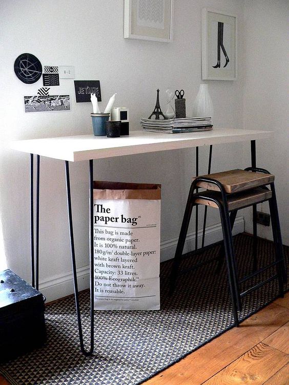 a black and white console table or desk, with black hairpin legs, some decor and a mini gallery wall is cool