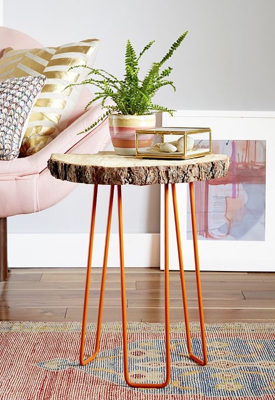 A side table of a tree slice and orange hairpin legs is a cool decor piece for a living room in mid century modern style
