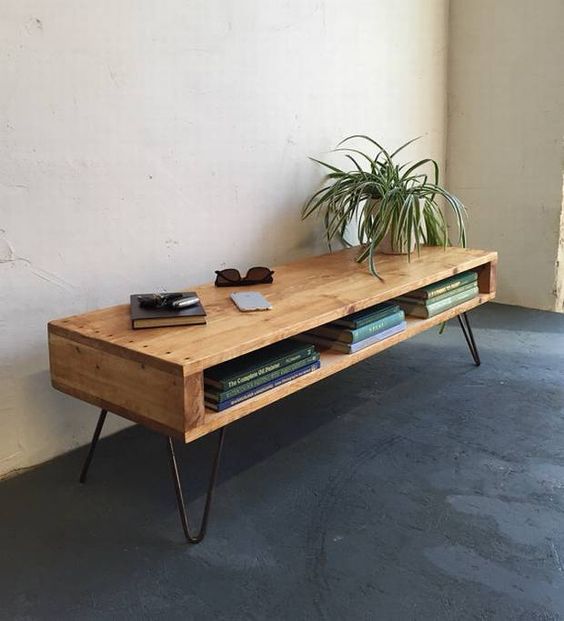 A console table with a storage compartment, with hairpin legs and some books plus a potted plant for a mid century modern space