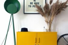 15 a mid-century modern entryway with a mustard locker, pampas grass, a green floor lamp and a metal basket for storage