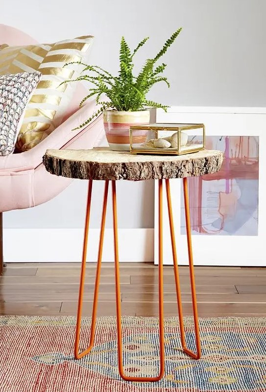 A side table of a tree slice and orange hairpin legs is a cool decor piece for a living room in mid century modern style