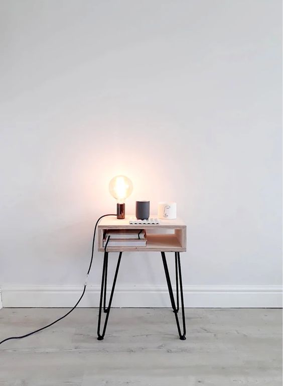 a small nightstand of a box and hairpin legs, with a bulb lamp is a stylish idea for a modern or Scandinavian space
