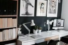 a Scandinavian home office with a black wall, a shelving unit and a shared white desk, bold artworks for cool wall decor