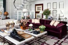 a beautiful living room with white paneled walls, a creamy and a purple sofa, a cluster of coffee tables and a printed white and purple rug