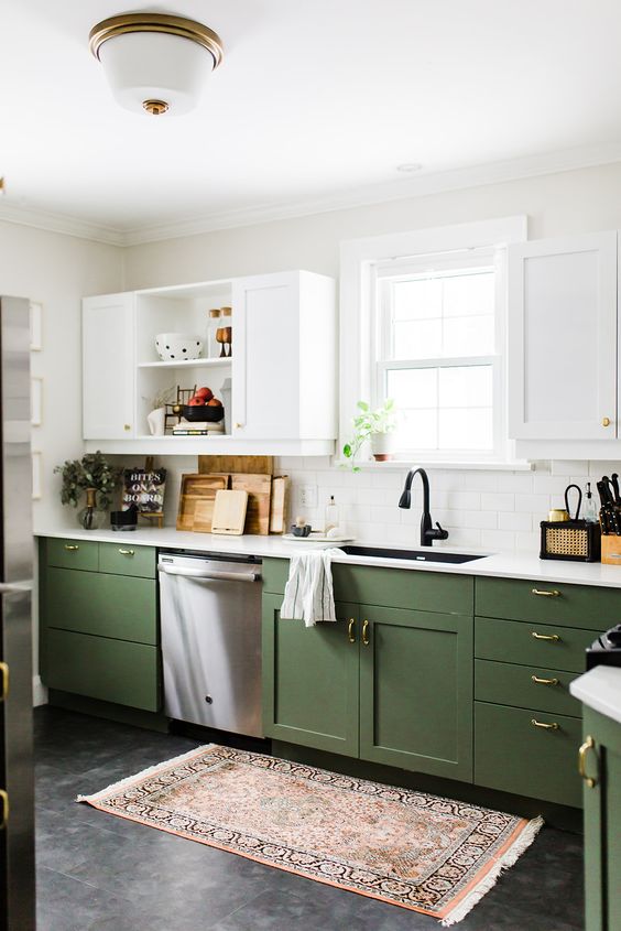 a farmhouse kitchen with green and white cabinets, shaker and open ones, white countertops, a white tile backsplash, black fixtures