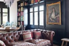 a large moody open layout with a brown leather Chesterfield as the main statement piece
