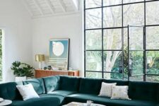 a large teal velvet L-shaped sectional sofa is a statement piece in this airy space