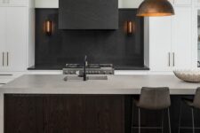 a minimalist kitchen with white cabinets and a dark-stained kitchen island, black soapstone countertops and a backsplash and a concrete countertop