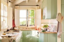 a mint farmhouse kitchen with beadboard cabinets, butcherblock countertops and lots of natural light