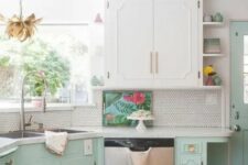 a retro kitchen done in white and mint, with elegant cabinets, white stone countertops, a white penny tile backsplash and gold fixtures