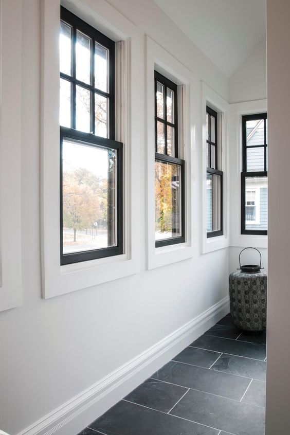 A series of black frame double hung windows gives a lot of natural light to the space and adds interest with black framing