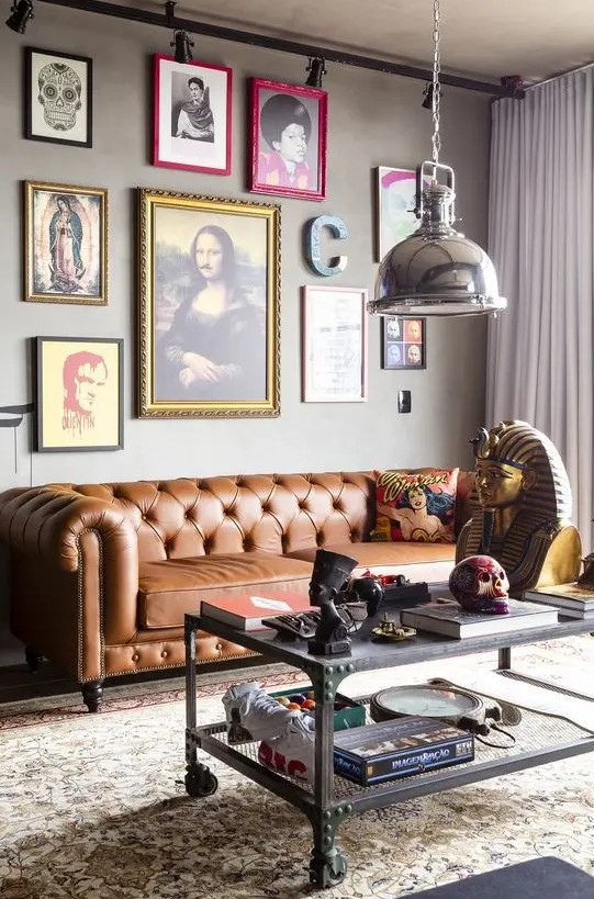 a whimsical industrial living room with a brown leather Chesterfield sofa, a bold and quirky gallery wall and a metal table