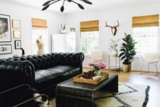 an eclectic living room with a black leather sofa, a black coffee table and chair, a gallery wall, a printed boho rug