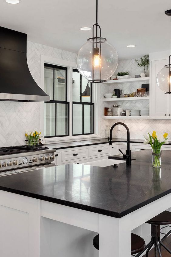 An elegant and polished black and white kitchen with shaker cabinets, open shelves, black countertops and black frame double hung windows