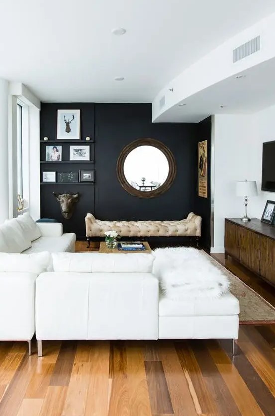a chic modern space with a black wall, creamy furniture, walls and a ceiling and cool accessories and details