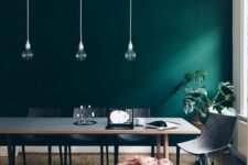 08 a Scandinavian dining space with a dark green accent wall, a grey table and chair, pendant bulbs is chic and cool