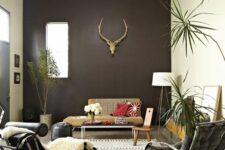 09 a catchy boho living room with a chocolate brown accent wall, a neutral sofa, a black and grey lounger, a chair and a pouf and some plants