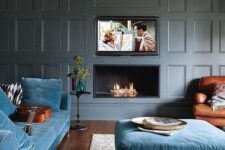 19 a modern luxurious living room with grey paneled walls, blue furniture and a built-in fireplace and TV