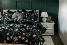 27 a beautiful guest bedroom with a dark green paneled wall, a neutral upholstered bed with bold floral bedding, white nightstands