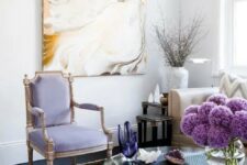 38 an airy refined living room with a lilac antique chair, a statement artwork, a dark rug and a glass coffee table with decor and flowers