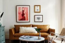 52 a colorful living room with a rust-colored leather sofa, beige chairs, a round table, a pink rug and a blue inlay dresser, a whimsical mini gallery wall