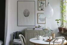 54 a lovely Scandinavian dining zone with a grey cabinet, a round table and vintage chairs, a mini gallery wall and some greenery