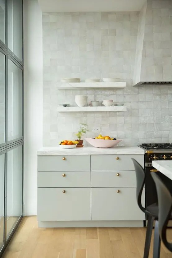 a plain dove grey kitchen with gorgeous mother of pearl Zellige tiles covering the whole wall and the hood for more interest
